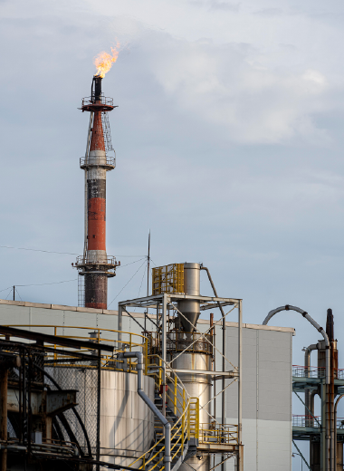 Industrial scene with an oil refinery tower, symbolizing Pingxiang Jianghua’s contributions to the oil and gas industry through chemical packing solutions.