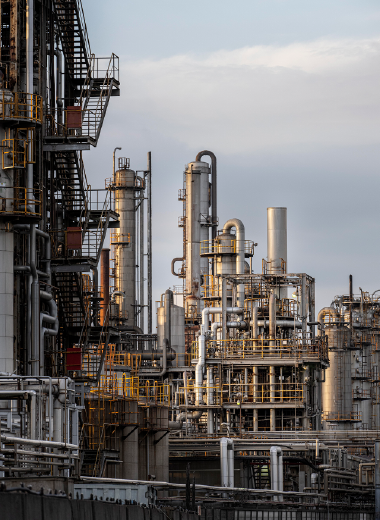 Petrochemical facility with industrial towers and pipes, representing Pingxiang Jianghua’s role in providing chemical packing solutions for the petrochemical industry.